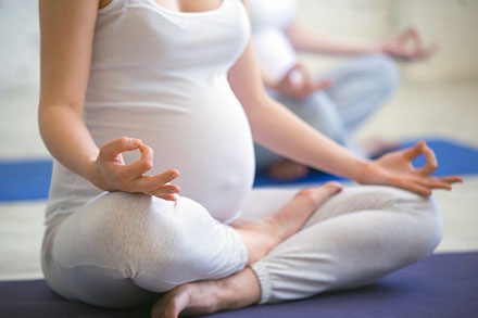 Schwangere Frau beim Meditieren und Yoga machen