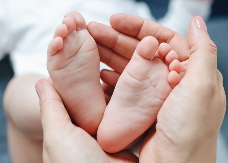 Babyfüße werden in Händen gehalten
